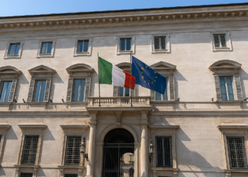 Palazzo storico italiano con bandiere italiana ed europea, simbolo di opportunità di investimenti immobiliari pubblici