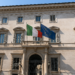 Palazzo storico italiano con bandiere italiana ed europea, simbolo di opportunità di investimenti immobiliari pubblici