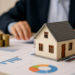 Modello di casa su documenti finanziari con grafici e monete, simbolo di investimento in nuda proprietà