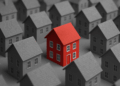 Mutui e mercato immobiliare in Italia rappresentati da una casa rossa tra abitazioni grigie