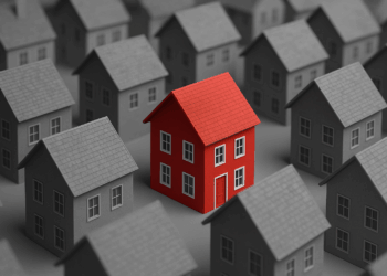 Mutui e mercato immobiliare in Italia rappresentati da una casa rossa tra abitazioni grigie