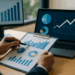 Professionista analizza grafici finanziari su NPE in ufficio moderno con laptop e monitor