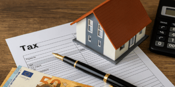 Modello di casa su documenti fiscali con euro e calcolatrice, concetto di detrazione IVA immobili