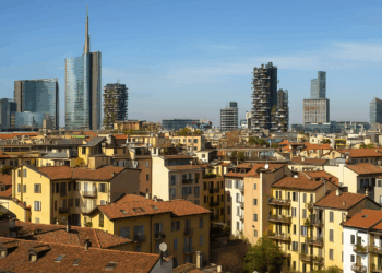 Affitti Milano, panorama con tetti in cotto e grattacieli moderni sotto un cielo azzurro