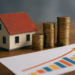 Miniatura di casa con pile di monete e grafico di crescita: concetto di investimento immobiliare